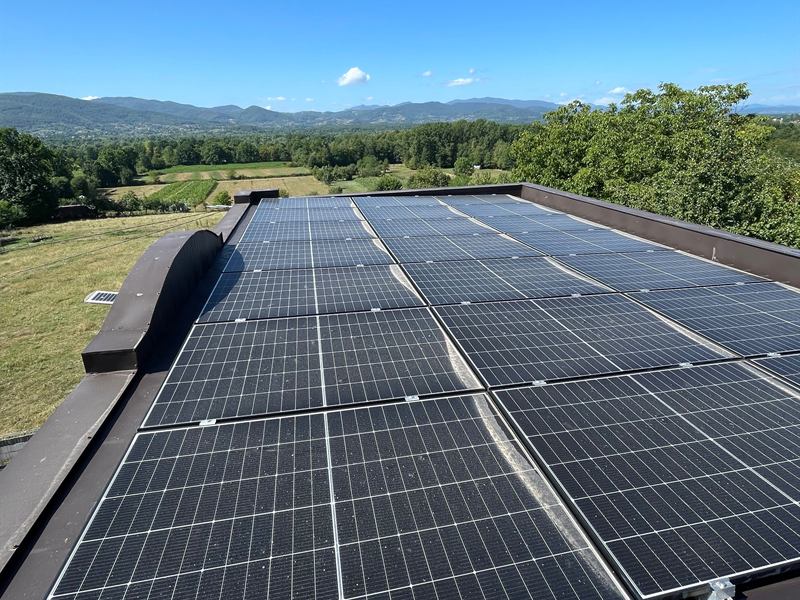 Solarni paneli na ravnom limenom krovu sa pogledom na brda
