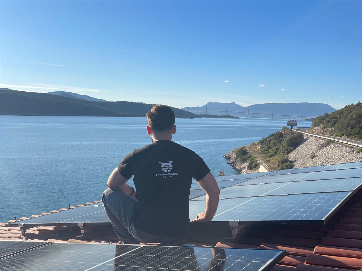 Član ThermoDrone Solar tima na krovu sa panelima, pogled na more i Pelješki most